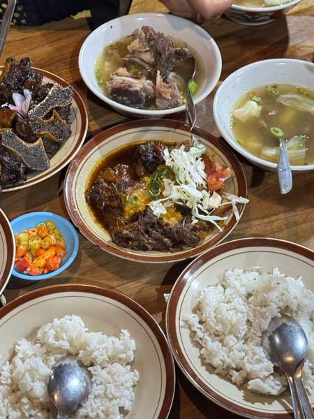 Yogyakarta selalu punya cara untuk membuat wisatawan jatuh cinta—bukan hanya lewat budaya dan keramahan warganya, tetapi juga melalui kuliner yang autentik dan beragam. Dari makanan tradisional legendaris hingga tempat makan modern dengan konsep unik, wisata kuliner di Jogja menjadi bagian penting dari pengalaman liburan.
Bagi wisatawan yang ingin menjelajahi Jogja secara utuh, mencicipi kuliner khas adalah agenda yang tak boleh dilewatkan. Berikut ini 10 rekomendasi kuliner di Jogja yang paling ikonik, sering direkomendasikan wisatawan, dan layak masuk ke dalam itinerary tour & travel.
1. Gudeg Sagan – Gudeg Legendaris dengan Rasa Autentik
Gudeg Sagan adalah salah satu ikon kuliner Jogja yang sudah dikenal sejak lama. Berbeda dengan gudeg yang cenderung manis, Gudeg Sagan memiliki cita rasa yang lebih seimbang, gurih, dan kaya rempah. Disajikan dengan ayam kampung, telur, krecek, dan sambal khas, tempat ini sering menjadi destinasi wajib wisatawan.
Lokasinya yang strategis membuat Gudeg Sagan cocok dikunjungi untuk sarapan atau makan siang sebelum memulai city tour Jogja.
2. Serodja Prawirotaman – Kuliner Modern dengan Sentuhan Lokal
Serodja Prawirotaman dikenal sebagai restoran dengan konsep modern namun tetap mengangkat rasa lokal. Suasananya nyaman, artistik, dan cocok untuk wisatawan yang ingin makan santai setelah menjelajahi kawasan selatan Jogja.
Menu di Serodja memadukan cita rasa nusantara dan presentasi modern, menjadikannya favorit wisatawan lokal maupun mancanegara. Tempat ini sangat cocok dimasukkan dalam itinerary wisata kuliner Prawirotaman.
3. Por Aqui Prawirotaman – Vibes Internasional di Jantung Jogja
Por Aqui Prawirotaman menawarkan pengalaman makan dengan nuansa internasional yang kuat. Desain tempatnya unik, penuh warna, dan menghadirkan atmosfer santai khas kawasan Prawirotaman.
Por Aqui sering menjadi pilihan untuk makan malam atau nongkrong sore hari, terutama bagi wisatawan muda dan pencinta suasana urban. Tempat ini mencerminkan sisi modern Jogja yang dinamis dan kosmopolitan.
4. Warung Makan Yu Ira Pasar Ngasem – Sarapan Tradisional Favorit Lokal
Terletak di area Pasar Ngasem, Warung Makan Yu Ira dikenal sebagai tempat sarapan favorit warga lokal. Menu sederhana seperti sayur, lauk tradisional, dan masakan rumahan menghadirkan rasa Jogja yang autentik.
Warung ini cocok dikunjungi pagi hari sebelum wisata ke Taman Sari atau Keraton Yogyakarta. Pengalaman makan di sini memberikan nuansa lokal yang kuat dan membumi.
5. Wingko Ngasem – Jajanan Legendaris yang Selalu Dicari
Wingko Ngasem adalah jajanan tradisional berbahan kelapa yang sudah menjadi ikon Pasar Ngasem. Teksturnya lembut dengan aroma kelapa yang khas, sangat cocok sebagai oleh-oleh atau camilan saat berjalan-jalan.
Banyak wisatawan rela antre demi mencicipi wingko ini, terutama di pagi hari. Rasanya sederhana namun membekas—seperti Jogja itu sendiri.
6. Iga Bajog – Surga Pecinta Iga
Iga Bajog merupakan destinasi kuliner populer bagi pecinta iga sapi. Dagingnya empuk, bumbunya meresap, dan porsinya mengenyangkan. Tempat ini sering ramai oleh wisatawan dan warga lokal.
Iga Bajog cocok untuk makan siang atau makan malam setelah seharian berkeliling Jogja, terutama bagi wisatawan yang ingin menu berat dan memuaskan.
7. Tempo Gelato – Dessert Wajib Saat di Jogja
Tempo Gelato adalah tempat dessert yang hampir selalu masuk daftar rekomendasi wisata Jogja. Pilihan rasa gelatonya beragam, mulai dari cokelat, vanila, hingga rasa lokal yang unik.
Tempat ini sangat populer sebagai destinasi penutup setelah wisata kuliner atau city tour. Cocok untuk semua kalangan, dari keluarga hingga anak muda.
8. Kopi Merapi – Ngopi dengan View Gunung
Kopi Merapi menawarkan pengalaman minum kopi dengan latar pemandangan alam yang menenangkan. Udara sejuk dan suasana alami membuat tempat ini cocok untuk wisata santai atau healing trip.
Kopi Merapi sering menjadi destinasi favorit dalam itinerary wisata alam dan kuliner di sekitar Jogja.
9. Warung Mbak Pesta – Makan Enak dengan Suasana Rumahan
Warung Mbak Pesta dikenal dengan suasana sederhana dan rasa masakan yang konsisten. Menu-menu rumahan khas Jawa menjadi daya tarik utama tempat ini.
Warung ini cocok untuk wisatawan yang ingin merasakan kuliner Jogja yang apa adanya, hangat, dan tanpa gimmick berlebihan.
10. Sate Klathak Pak Pong – Rekomendasi Tambahan Paling Ikonik
Sebagai rekomendasi tambahan paling ikonik, Sate Klathak Pak Pong adalah pilihan yang hampir selalu direkomendasikan. Sate kambing yang dibakar dengan jeruji besi ini memiliki rasa gurih khas dan tekstur daging yang empuk.
Sate Klathak sering menjadi menu wajib bagi wisatawan yang ingin mencoba kuliner unik khas Jogja.
Kesimpulan
Wisata kuliner di Jogja adalah perjalanan rasa yang tak terlupakan. Dari Gudeg Sagan yang legendaris, Serodja dan Por Aqui yang modern, hingga Wingko Ngasem dan Warung Yu Ira yang tradisional, setiap tempat menawarkan cerita dan pengalaman berbeda.
Bagi wisatawan, mengunjungi tempat-tempat ini bukan hanya soal makan, tetapi juga cara terbaik untuk mengenal Jogja lebih dekat. Itulah mengapa 10 rekomendasi kuliner di atas sangat layak dimasukkan ke dalam itinerary tour & travel Yogyakarta.