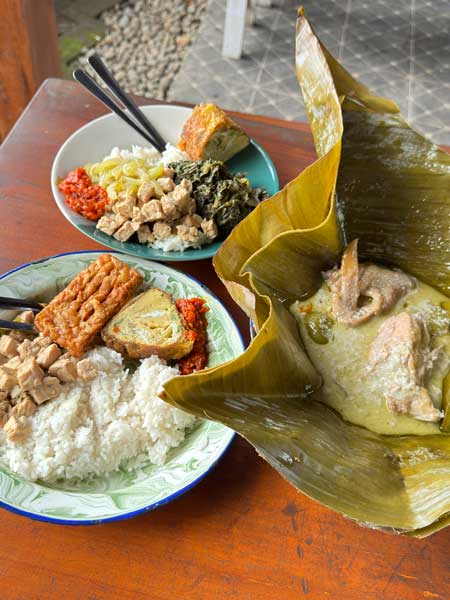 Yogyakarta selalu punya cara untuk membuat wisatawan jatuh cinta—bukan hanya lewat budaya dan keramahan warganya, tetapi juga melalui kuliner yang autentik dan beragam. Dari makanan tradisional legendaris hingga tempat makan modern dengan konsep unik, wisata kuliner di Jogja menjadi bagian penting dari pengalaman liburan.
Bagi wisatawan yang ingin menjelajahi Jogja secara utuh, mencicipi kuliner khas adalah agenda yang tak boleh dilewatkan. Berikut ini 10 rekomendasi kuliner di Jogja yang paling ikonik, sering direkomendasikan wisatawan, dan layak masuk ke dalam itinerary tour & travel.
1. Gudeg Sagan – Gudeg Legendaris dengan Rasa Autentik
Gudeg Sagan adalah salah satu ikon kuliner Jogja yang sudah dikenal sejak lama. Berbeda dengan gudeg yang cenderung manis, Gudeg Sagan memiliki cita rasa yang lebih seimbang, gurih, dan kaya rempah. Disajikan dengan ayam kampung, telur, krecek, dan sambal khas, tempat ini sering menjadi destinasi wajib wisatawan.
Lokasinya yang strategis membuat Gudeg Sagan cocok dikunjungi untuk sarapan atau makan siang sebelum memulai city tour Jogja.
2. Serodja Prawirotaman – Kuliner Modern dengan Sentuhan Lokal
Serodja Prawirotaman dikenal sebagai restoran dengan konsep modern namun tetap mengangkat rasa lokal. Suasananya nyaman, artistik, dan cocok untuk wisatawan yang ingin makan santai setelah menjelajahi kawasan selatan Jogja.
Menu di Serodja memadukan cita rasa nusantara dan presentasi modern, menjadikannya favorit wisatawan lokal maupun mancanegara. Tempat ini sangat cocok dimasukkan dalam itinerary wisata kuliner Prawirotaman.
3. Por Aqui Prawirotaman – Vibes Internasional di Jantung Jogja
Por Aqui Prawirotaman menawarkan pengalaman makan dengan nuansa internasional yang kuat. Desain tempatnya unik, penuh warna, dan menghadirkan atmosfer santai khas kawasan Prawirotaman.
Por Aqui sering menjadi pilihan untuk makan malam atau nongkrong sore hari, terutama bagi wisatawan muda dan pencinta suasana urban. Tempat ini mencerminkan sisi modern Jogja yang dinamis dan kosmopolitan.
4. Warung Makan Yu Ira Pasar Ngasem – Sarapan Tradisional Favorit Lokal
Terletak di area Pasar Ngasem, Warung Makan Yu Ira dikenal sebagai tempat sarapan favorit warga lokal. Menu sederhana seperti sayur, lauk tradisional, dan masakan rumahan menghadirkan rasa Jogja yang autentik.
Warung ini cocok dikunjungi pagi hari sebelum wisata ke Taman Sari atau Keraton Yogyakarta. Pengalaman makan di sini memberikan nuansa lokal yang kuat dan membumi.
5. Wingko Ngasem – Jajanan Legendaris yang Selalu Dicari
Wingko Ngasem adalah jajanan tradisional berbahan kelapa yang sudah menjadi ikon Pasar Ngasem. Teksturnya lembut dengan aroma kelapa yang khas, sangat cocok sebagai oleh-oleh atau camilan saat berjalan-jalan.
Banyak wisatawan rela antre demi mencicipi wingko ini, terutama di pagi hari. Rasanya sederhana namun membekas—seperti Jogja itu sendiri.
6. Iga Bajog – Surga Pecinta Iga
Iga Bajog merupakan destinasi kuliner populer bagi pecinta iga sapi. Dagingnya empuk, bumbunya meresap, dan porsinya mengenyangkan. Tempat ini sering ramai oleh wisatawan dan warga lokal.
Iga Bajog cocok untuk makan siang atau makan malam setelah seharian berkeliling Jogja, terutama bagi wisatawan yang ingin menu berat dan memuaskan.
7. Tempo Gelato – Dessert Wajib Saat di Jogja
Tempo Gelato adalah tempat dessert yang hampir selalu masuk daftar rekomendasi wisata Jogja. Pilihan rasa gelatonya beragam, mulai dari cokelat, vanila, hingga rasa lokal yang unik.
Tempat ini sangat populer sebagai destinasi penutup setelah wisata kuliner atau city tour. Cocok untuk semua kalangan, dari keluarga hingga anak muda.
8. Kopi Merapi – Ngopi dengan View Gunung
Kopi Merapi menawarkan pengalaman minum kopi dengan latar pemandangan alam yang menenangkan. Udara sejuk dan suasana alami membuat tempat ini cocok untuk wisata santai atau healing trip.
Kopi Merapi sering menjadi destinasi favorit dalam itinerary wisata alam dan kuliner di sekitar Jogja.
9. Warung Mbak Pesta – Makan Enak dengan Suasana Rumahan
Warung Mbak Pesta dikenal dengan suasana sederhana dan rasa masakan yang konsisten. Menu-menu rumahan khas Jawa menjadi daya tarik utama tempat ini.
Warung ini cocok untuk wisatawan yang ingin merasakan kuliner Jogja yang apa adanya, hangat, dan tanpa gimmick berlebihan.
10. Sate Klathak Pak Pong – Rekomendasi Tambahan Paling Ikonik
Sebagai rekomendasi tambahan paling ikonik, Sate Klathak Pak Pong adalah pilihan yang hampir selalu direkomendasikan. Sate kambing yang dibakar dengan jeruji besi ini memiliki rasa gurih khas dan tekstur daging yang empuk.
Sate Klathak sering menjadi menu wajib bagi wisatawan yang ingin mencoba kuliner unik khas Jogja.
Kesimpulan
Wisata kuliner di Jogja adalah perjalanan rasa yang tak terlupakan. Dari Gudeg Sagan yang legendaris, Serodja dan Por Aqui yang modern, hingga Wingko Ngasem dan Warung Yu Ira yang tradisional, setiap tempat menawarkan cerita dan pengalaman berbeda.
Bagi wisatawan, mengunjungi tempat-tempat ini bukan hanya soal makan, tetapi juga cara terbaik untuk mengenal Jogja lebih dekat. Itulah mengapa 10 rekomendasi kuliner di atas sangat layak dimasukkan ke dalam itinerary tour & travel Yogyakarta.